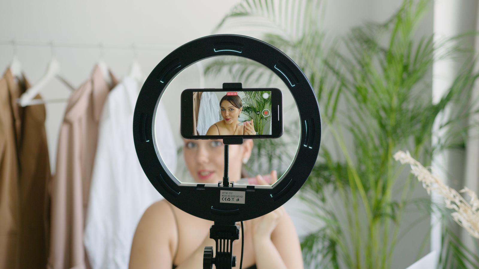 Content creator filming with a phone and a ring light