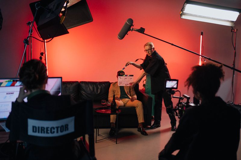 Film crew shooting a scene on a lit studio set with a clapperboard